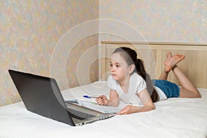 Distance learning online education. Schoolgirl studying at home with digital tablet laptop notebook