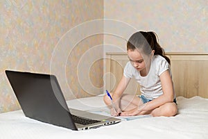 Distance learning online education. Schoolgirl studying at home with digital tablet laptop notebook