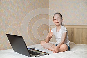 Distance learning online education. Schoolgirl studying at home with tablet laptop notebook and doing school homework