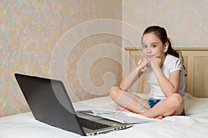 Distance learning online education. Schoolgirl studying at home with tablet laptop notebook and doing school homework