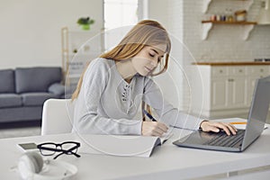 Distance learning. Young female student studying a lecture online using a laptop video call webinar class sitting at a