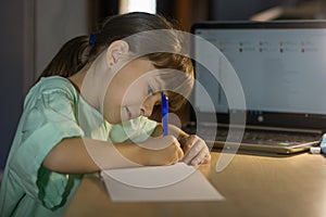 Distance online education. Little schoolgirl studies at home photo