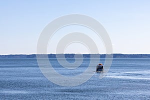 distant boat speeding off towards the horizon