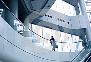 Distant businessman walking in a modern office building photo
