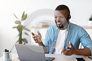 Distant Communication. Happy African American Guy In Headset Making Video Call