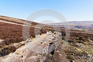 A distant group of people wlak up a rocky footpath on Derwent Moor photo