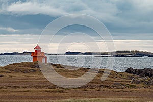 Distant orange modern lighthouse on the coastline