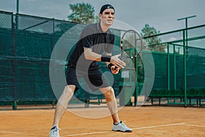 Distant plan of Man Holding Racket In Both Hands To Straighten Strike While Waiting For Ball Serving At Tennis Court.