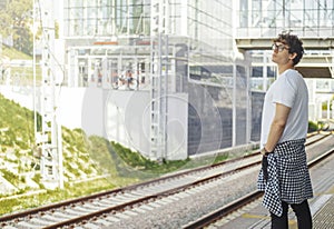 Distant plan of young attractive man waiting for train in metro station.