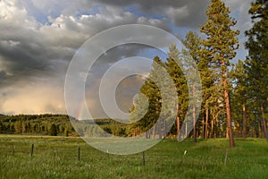 Distant Rainbow in the Breaking Clouds