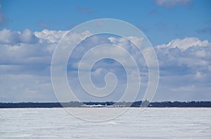 The distant shore of a frozen river