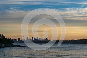 Distant silhouette of Sydney cityscape at dusk, on sunset