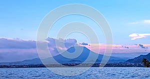 Distant susnset view of Nyiragongo Mountain in Democratic Republic of Congo, seen from Lake Kivu, Rwanda.