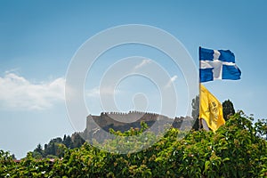 Distant view at Lindos Town and Castle with ancient ruins of the Acropolis on sunny warm day. Island of Rhodes, Greece. Europe