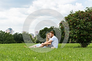 distant view of redhead couple sitting on grass