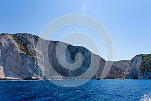 Distant view of Shipwreck bay Navagio and surounding cliffs in summer noon