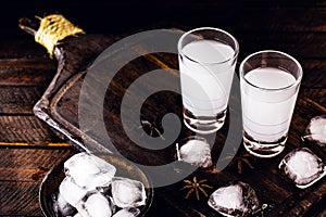 Distilled drink,anise base, on wooden background. Traditional Turkish and Greek appetizer, known as Ouzo, Uzo, Raki, arak or raki