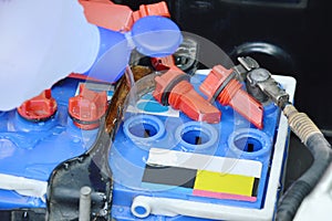 Distilled water flowing from plastic bottle filling in car batteries