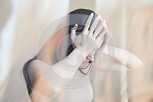 Distorted portrait of young woman struggling with headache