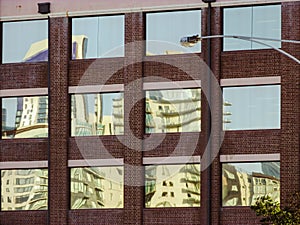 Distorted reflection of skyscraper on old factory windows