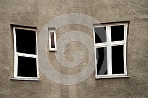 Distorted window with white frame on grey old wall architecture
