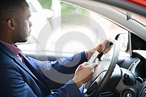 Distracted African Man Texting On Mobile Phone