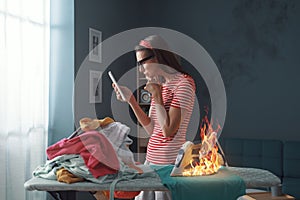Distracted careless housewife burning clothes with the iron