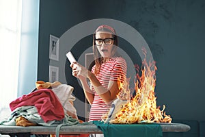Distracted careless housewife burning clothes with the iron photo