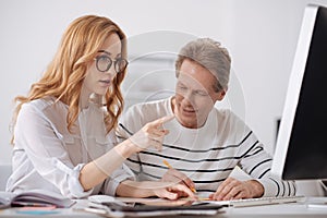 Distracted elderly manager flirting with young colleague at work photo