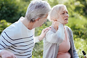 Distracted pensioner feeling terrible pain in the neck outdoors