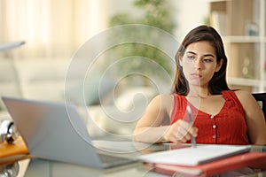 Distracted student waiting looking at laptop