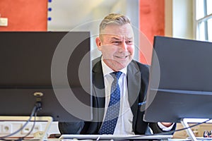 Distraught businessman grimacing at his computer screen