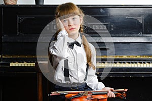 Distraught or distressed girl clutching her head and holding a violin