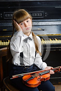 Distraught or distressed girl clutching her head and holding a violin