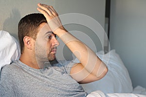 Distraught man with hand in forehead