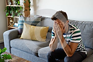 Distraught man sitting with his head in his hands