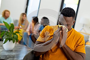 Distressed african american man holding tissue and crying in group therapy session