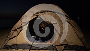 Distressed black man crying in tent, homeless refugee ill and hungry in camp