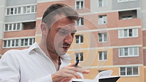 Distressed businessman in a white shirt looking through records, embezzlement.