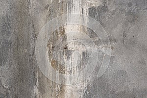 Distressed gray concrete wall with mildew stains and white paint streaks background texture