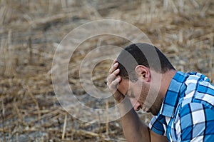 Distressed man with his hand on his head.