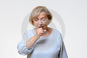 Distressed senior woman coughing