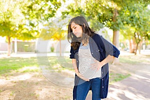 Distressed woman having contractions outdoors