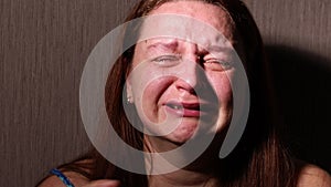 Distressed woman hysterically cry and speak in dark closeup. Tears roll down cheeks. Splash out emotions, weep bitterly.