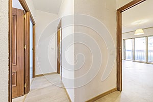 Distributing corridors of a house with light oak flooring and sapele wood doors with access to other rooms with terraces