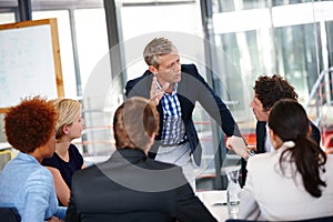 Distributing tasks to the team. Cropped shot of a group of business professionals in an office meeting.