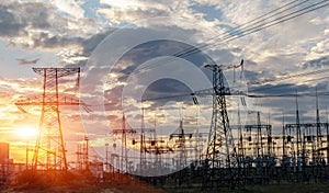 Distribution electric substation with power lines and transformers, at sunset