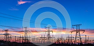 Distribution electric substation with power lines and transformers, at sunset photo