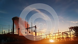 Distribution electric substation with power lines and transformers, at sunset