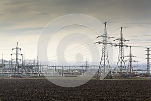 Distribution power station with electricity pylons and dramatic cloudy sky